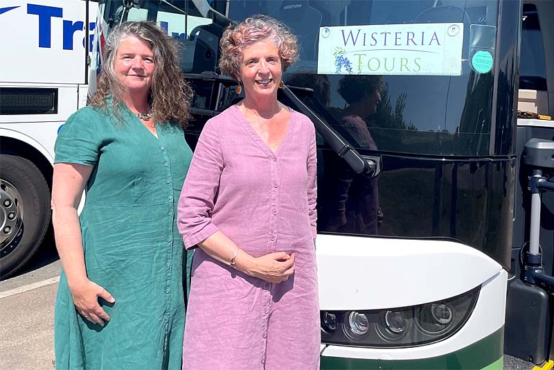 sue and jackie from wisteria tours stand by coach