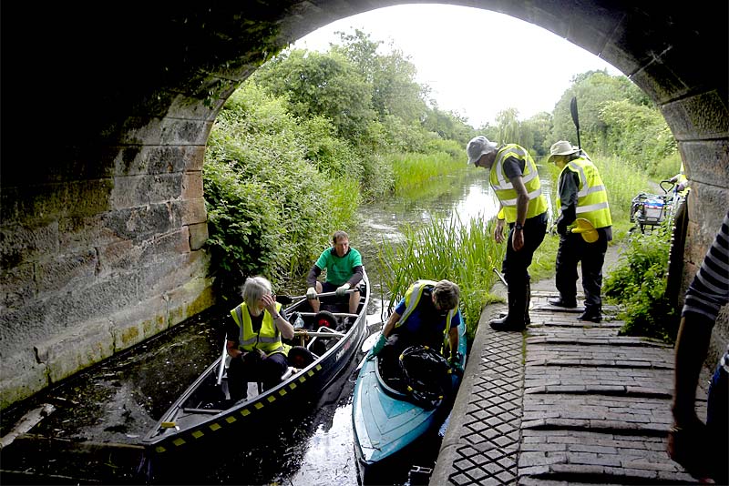 volunteers in canoes clearing newport canal